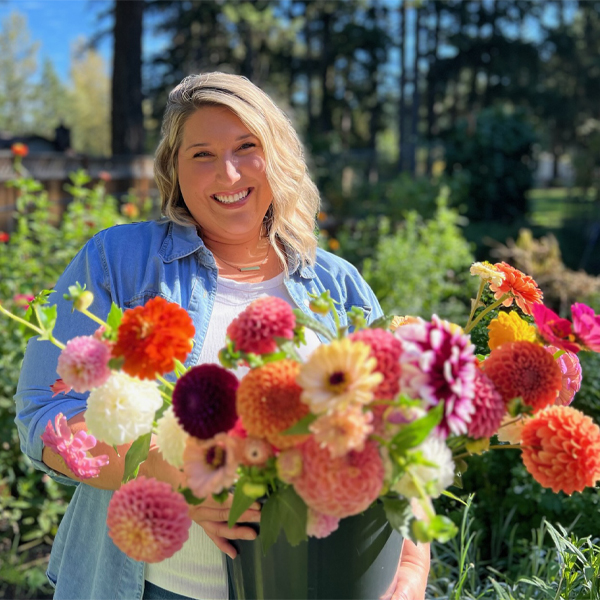 Shayna Dennett holding a bucket of colorful blooms