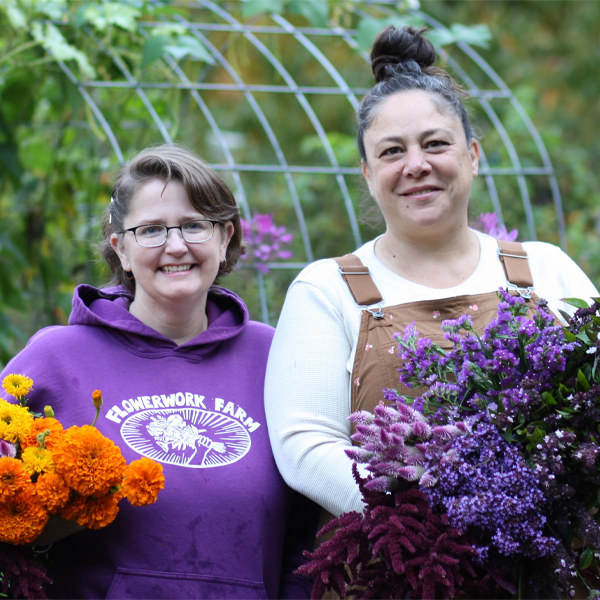 Suna Turgay and her business parter with armloads of coloful blooms